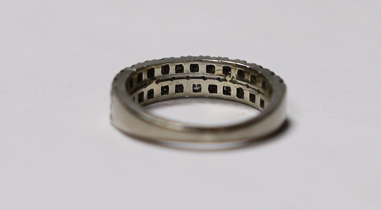 A white metal and two row round cut diamond set half eternity ring, size M, gross weight 3.9 grams.